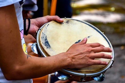 Detail of musician playing tambourine during a samba performance at carnival in the streets of