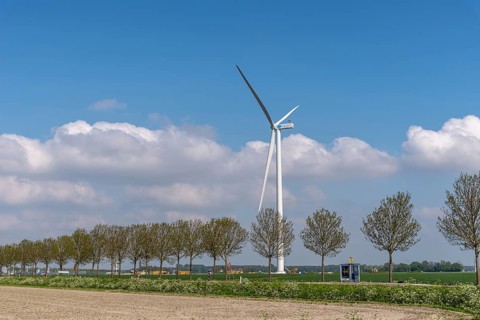 Lelystad, Netherlands, May 07, 2022: Windmill, row of trees polder and road