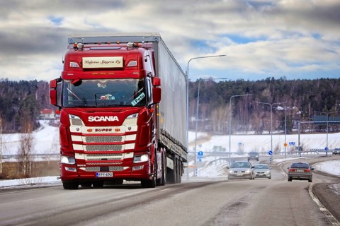 Customized red Scania 500 S super truck pulls semi trailer in traffic on a day of winter. Salo,