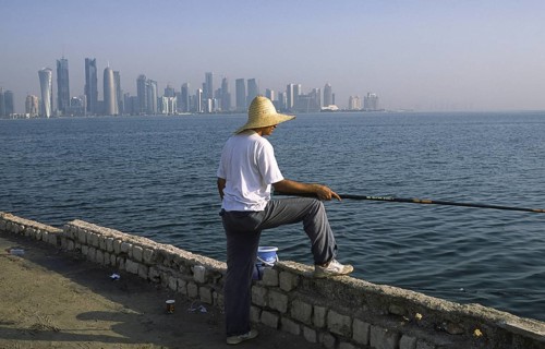 13.09.2010, Doha, Qatar Qatar, A man fishing on the promenade along Al Corniche Street with a view