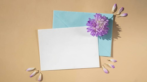 Composition with empty paper note and envelope beautiful spring blue flowers on beige background.