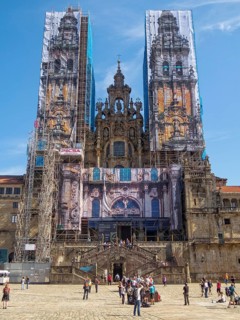 Western facade of the cathedral behind scaffolding and mural panels during restoration, Santiago de