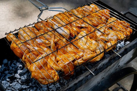 BBQ picnic time Roasted chicken legs and wings on grill. Grilling meat on outdoor grill grid tasty