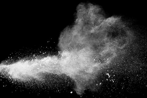 Bizarre forms of white powder explosion cloud against black background.White dust particles splash
