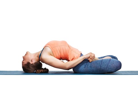 Beautiful sporty fit yogini woman practices yoga asana Matsyasana, fish pose in studio isolated on