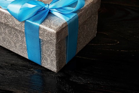 Gift birthday Christmas present concept, silver gift box with blue ribbon on dark wooden background