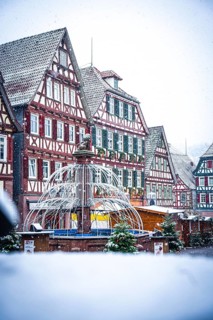 Half-timbered house backdrop on a snow-covered Christmas market with winter decorations, Black