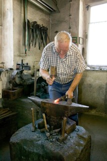 Blacksmith at the Demitz-Thumitz granite works. The granite processing tools have to be reforged,
