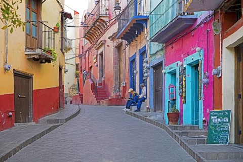 Colourful colonial era houses with balconies in alley paved with square cut stones in the city