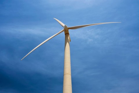 Green renewable alternative energy concept, wind generator turbine generating electricity in blue