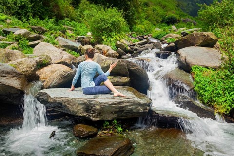 Yoga exercise outdoors, woman doing Ardha matsyendrasana asana, half spinal twist pose at tropical