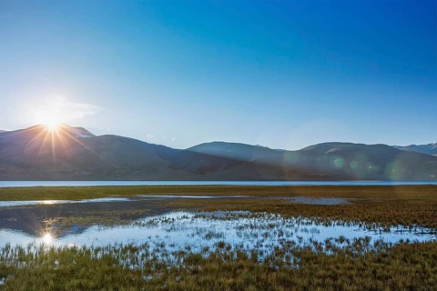 Lake Tso Moriri in Himalayas on sunrise. Ladakh, Inda. With lens flare