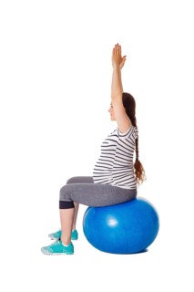 Pregnancy exercise concept, pregnant woman doing exercises with exercise ball isolated on white