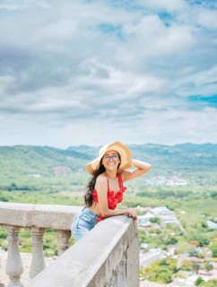 Happy tourist woman in hat on a viewpoint. Portrait of vacationer girl in a viewpoint. Travel and