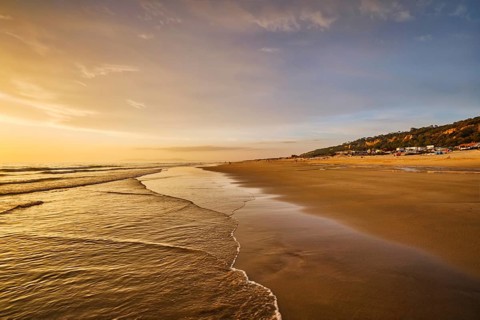 Atlantic ocean sunset with surging waves at Fonte da Telha beach, Costa da Caparica, Portugal,
