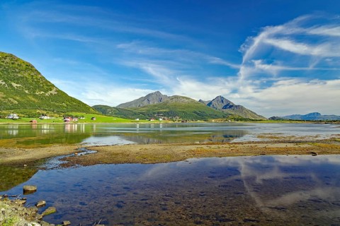 Crystal clear bay with shallow water, green mountain landscape, Leknes, Vestvågøy, Nordland,