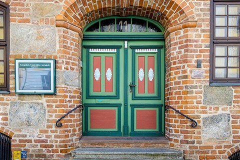 Historic door richly decorated with ornamentation and carvings of the heritage-protected building