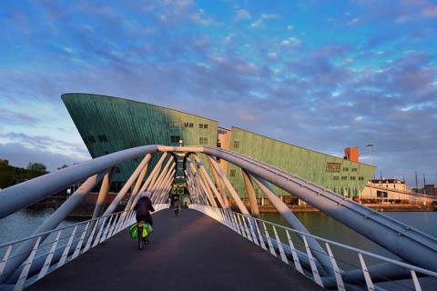 AMSTERDAM, NETHERLANDS, MAY 9, 2017: NEMO Science museum and Mr. J. van der Veldebrug bridge. It is