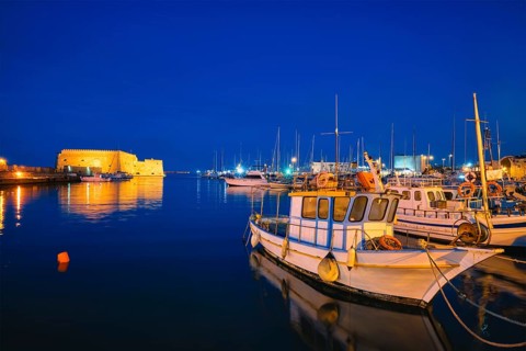 Venetian Fort castle in Heraklion and moored Greek fishing boats in port, Crete Island, Greece in
