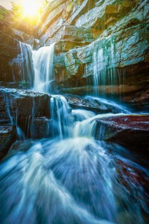 Tropical waterfall with sun rays. With lens flare and light leak