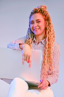 Smiling young woman shows the comfortability of using wireless technology