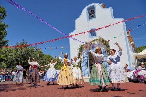 Women in traditional dress dance in front of the Ermita de San Vicent chapel, annual fiesta in