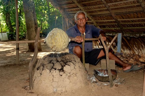 Man of a Caboclos tribe heating up a rubber ball, Amazon state, Brazil, South America