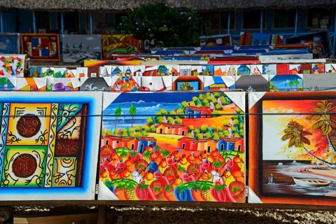 Art stall with paintings depicting tropical landscapes and seascapes, market, Bayahibe, Dominican