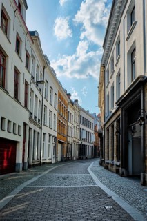Antwerp cobblestone street with alley row of medieval houses at the old European city port, Belgium
