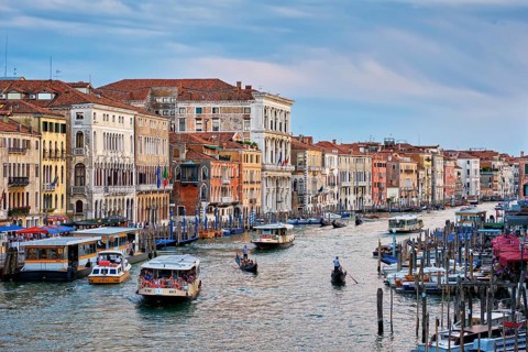 VENICE, ITALY, JUNE 27, 2018: Grand Canal with boats, vaporetto and gondolas on sunset from Rialto
