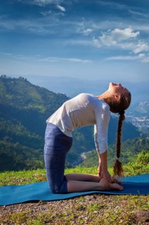 Yoga, outdoors young beautiful slender woman yoga instructor doing camel pose Ustrasana asana