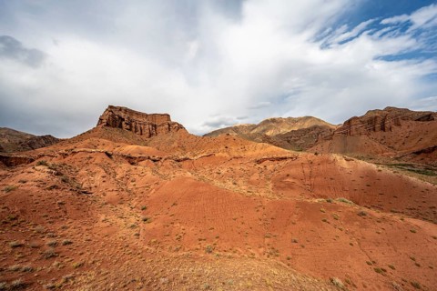 Eroded mountain landscape with sandstone cliffs, red and orange rock formations, Konorchek Canyon,