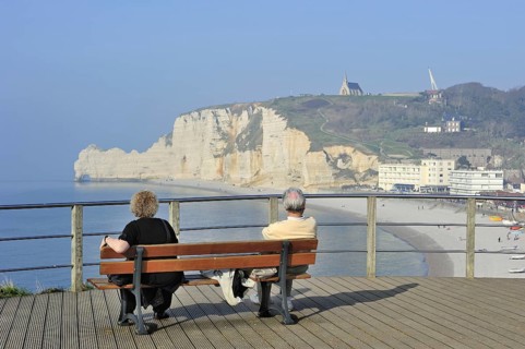 Elderly tourists looking at the chalk cliff Porte d'Amont and the chapel Notre-Dame-de-la-Garde at
