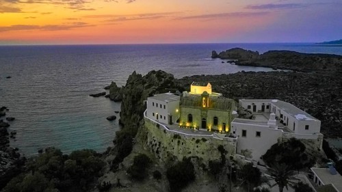 Drone shot, Gesmates Monastery, sea, illuminated church, illuminated chapel, dusk, sunset, cloudy
