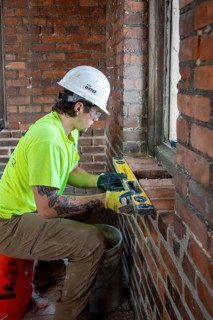 Detroit, Michigan, Journeyman bricklayer Tyler Tamer replaces bricks inside a bell tower of the