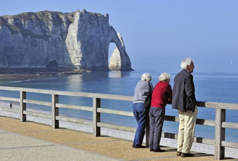 Elderly tourists and the Porte D'Aval, a natural arch in the chalk cliffs at Etretat, Côte