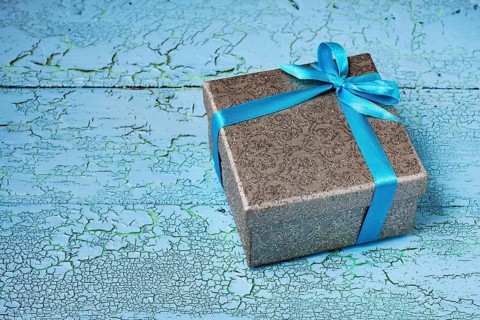 Gift birthday Christmas present concept, silver gift box with blue ribbon on blue painted wooden