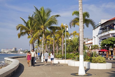 Mexican tourists walking along the Malecón, esplanade in city Puerto Vallarta, beach resort on the