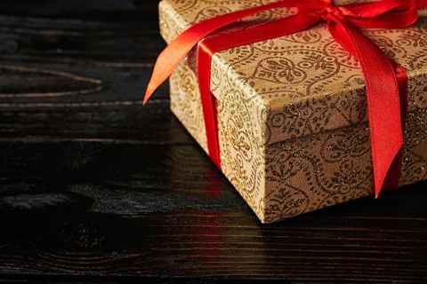 Gift birthday Christmas present concept, gift box with red ribbon on dark wooden background