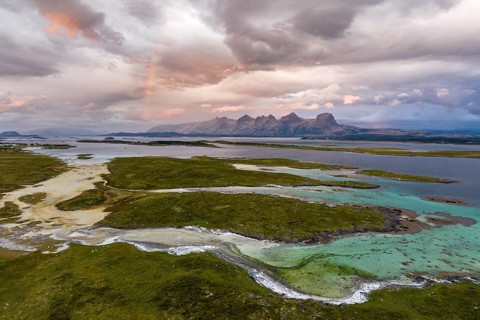 View of mountain range Seven Sisters from Herøy island, light mood with rainbow, Helgeland coast,