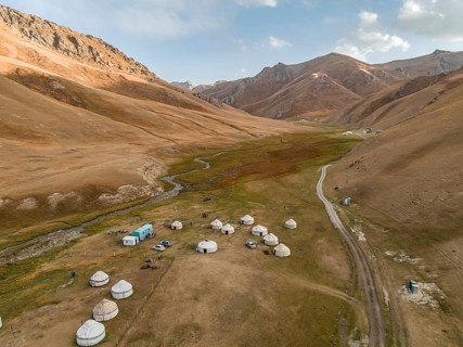 Aerial view, yurts in a mountain valley with a gravel road, Naryn region, Kyrgyzstan, Asia