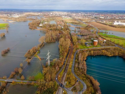 Aerial view of a flooded landscape with roads and trees, under a cloudy sky, flood, Christmas,