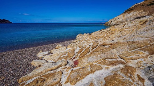 Rocky coast with turquoise water and blue sky, Lambi beach, pebble beach, Patmos, Dodecanese, Greek
