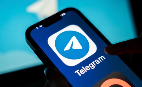 The social media Telegram messenger logo is being displayed on a smartphone screen and on a