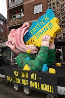 Vladimir Putin with his mouth open, devouring Ukraine, papier-mâché figure, satirical float by