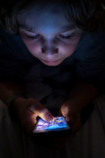 A boy plays computer games on a mobile phone, smartphone