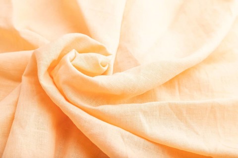 Fragment of orange linen tissue. Side view, natural textile background and texture. wave concept,