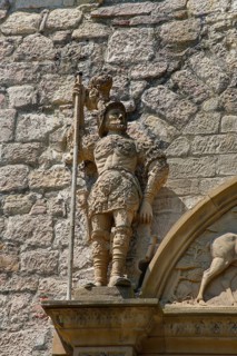 Stone figures, statue, male warrior above portal, detail, armour, weapons, decoration,