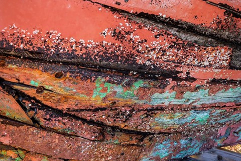 Colourful ship's planks, rotten hull and old planks of a ship, close-up of the underwater hull.