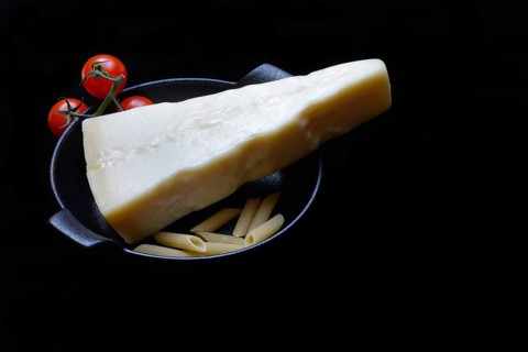 A piece of Parmesan cheese with tomatoes and pasta, Italy, Europe